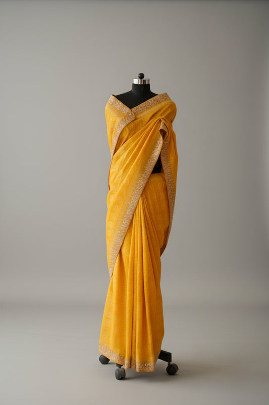 Yellow saree on a mannequin in a store setting with various products in the background.