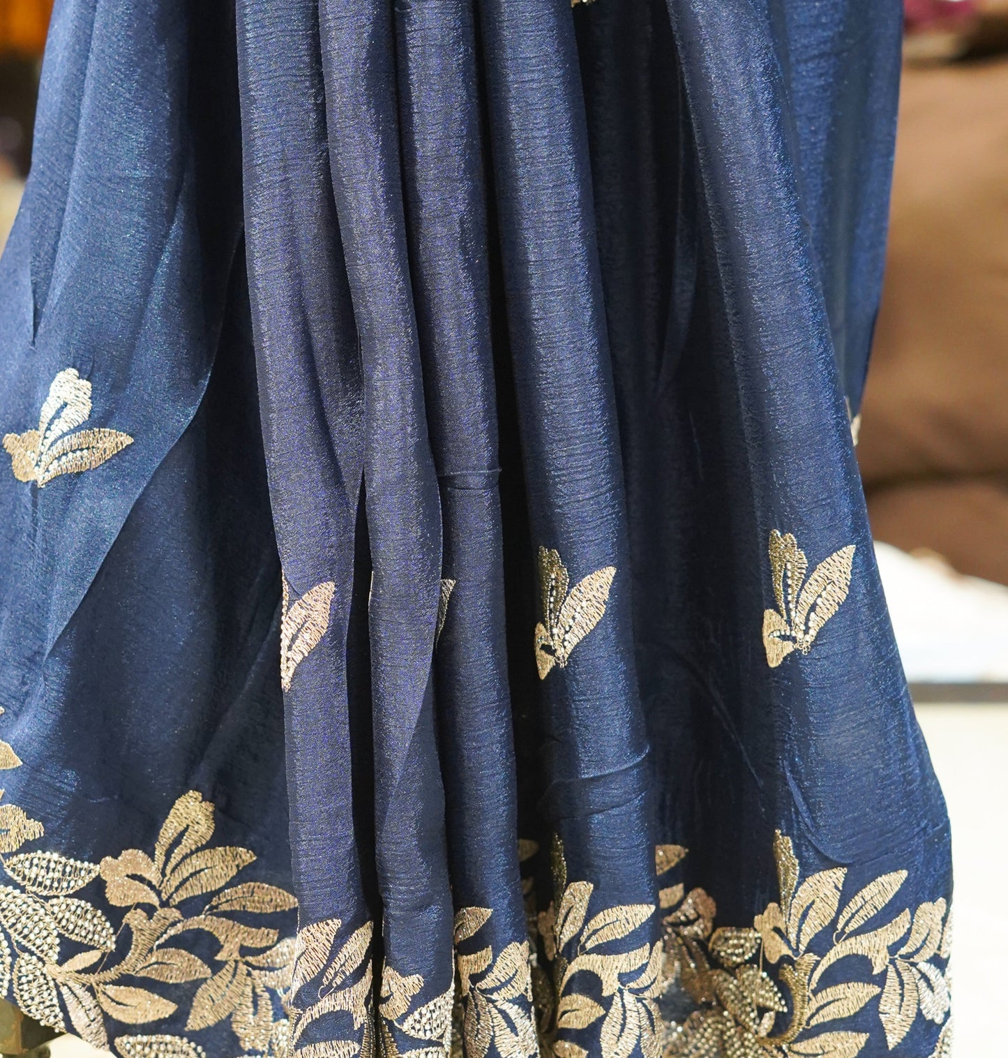 Blue fabric with gold floral patterns on a stand